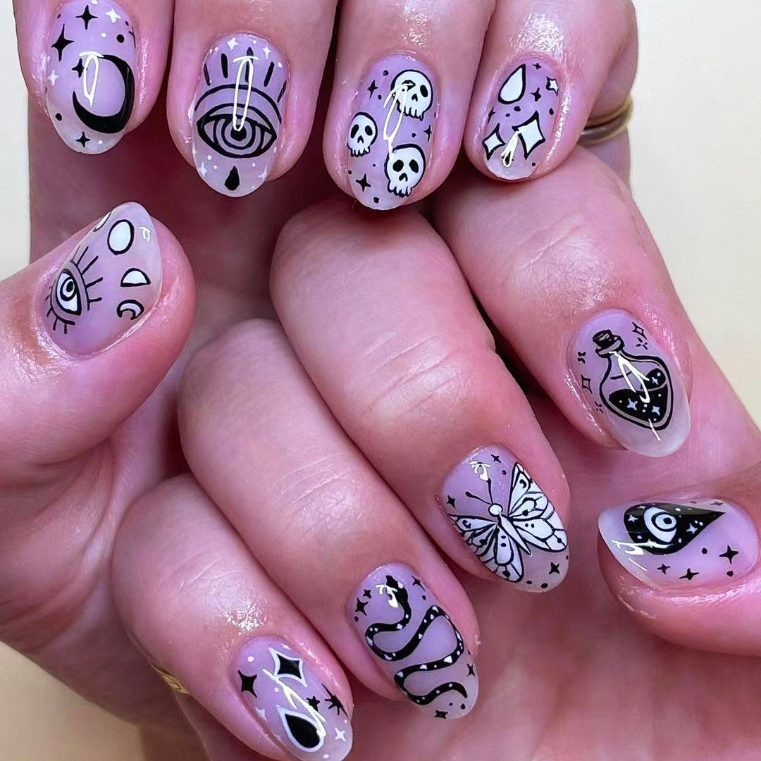 Nails with black and white designs on a light pink background