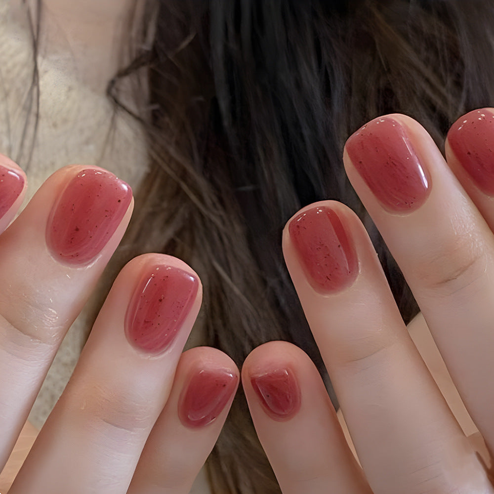 Close-up of hands with red nail polish against a blurred background