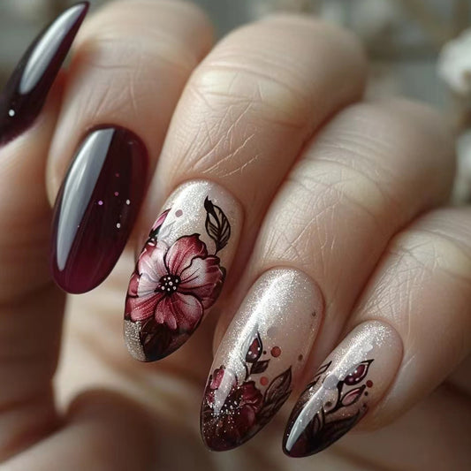 A set of long, burgundy almond-shaped nails with a floral design featuring roses and gold accents, and a square press-on nail product.