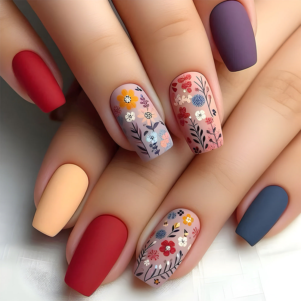 Close-up of hands with colorful nail designs on a neutral background