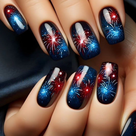 A set of square-shaped nails with a blue and black base, featuring sparkling red and white accents in the form of fireworks.