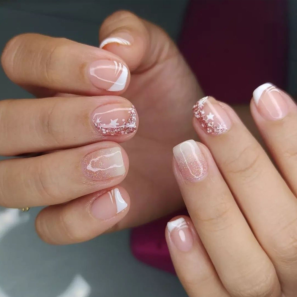 Close-up of hands with French manicure nails featuring star designs.