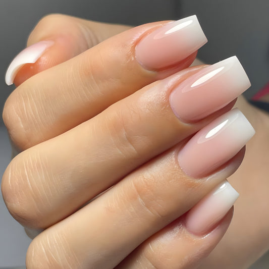 Close-up of a hand with pink and white nail polish on a neutral background