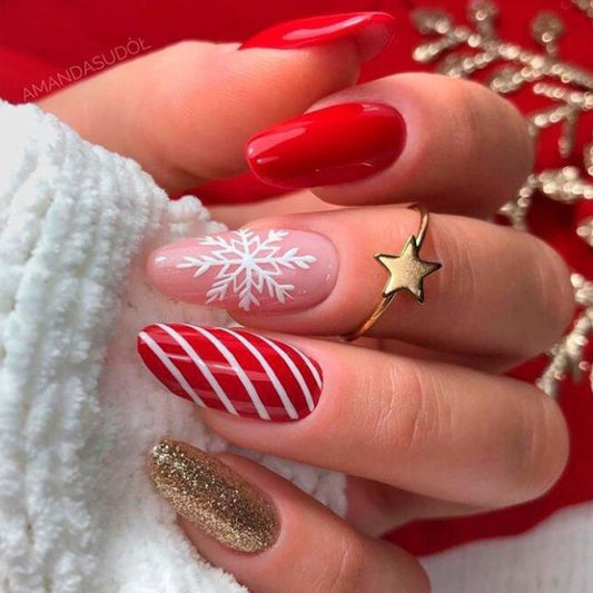 Close-up of a hand with festive nail art featuring red, white, and gold designs.