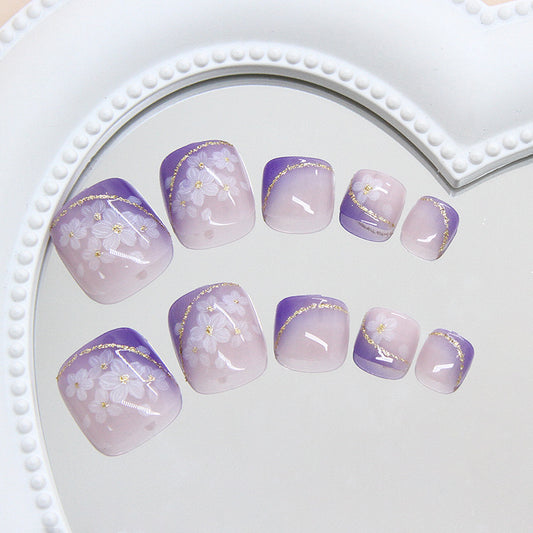 Set of purple and gold floral nail art on a white heart-shaped tray