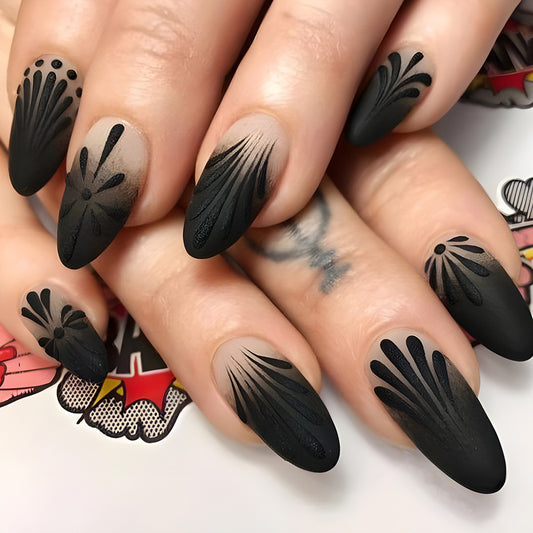 A set of press-on nails featuring intricate floral designs in black matte finish.