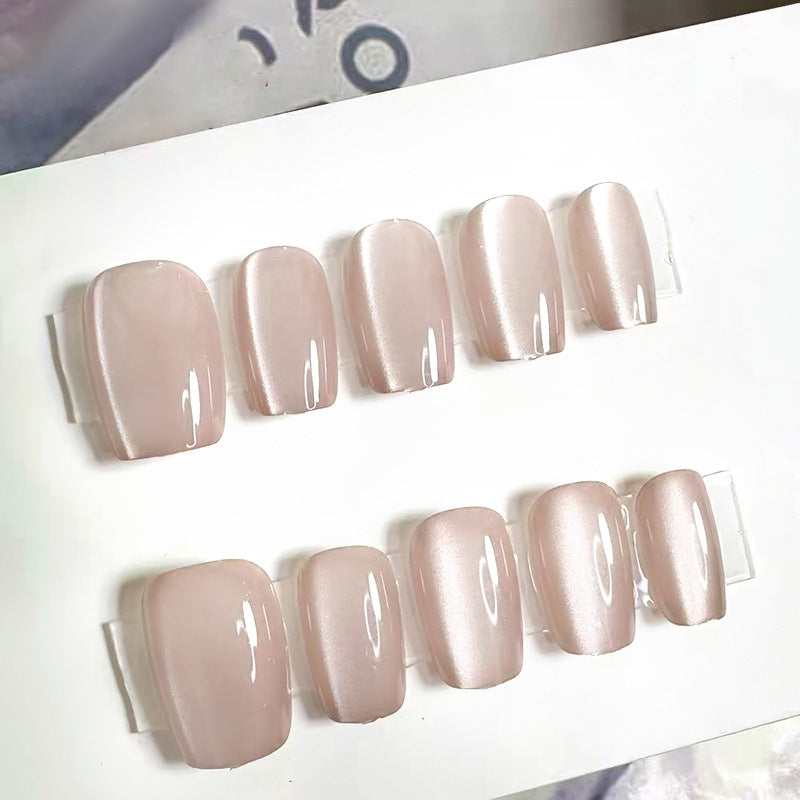 A set of blush pink glossy finish press-on nails laid out on a white surface.