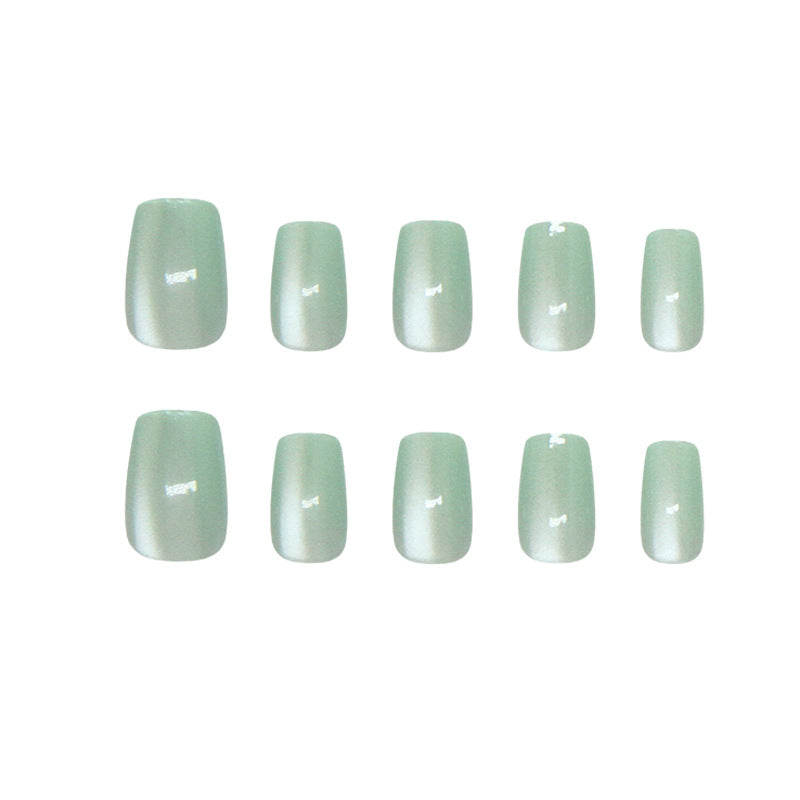 Set of light green nail polish strips on a white background