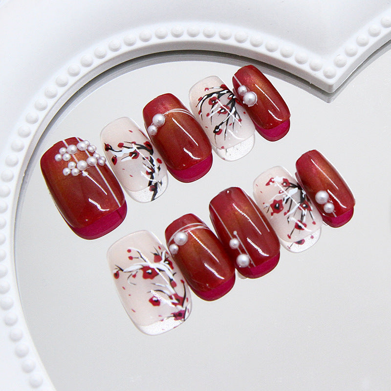 Nail art with red and white design on a white plate