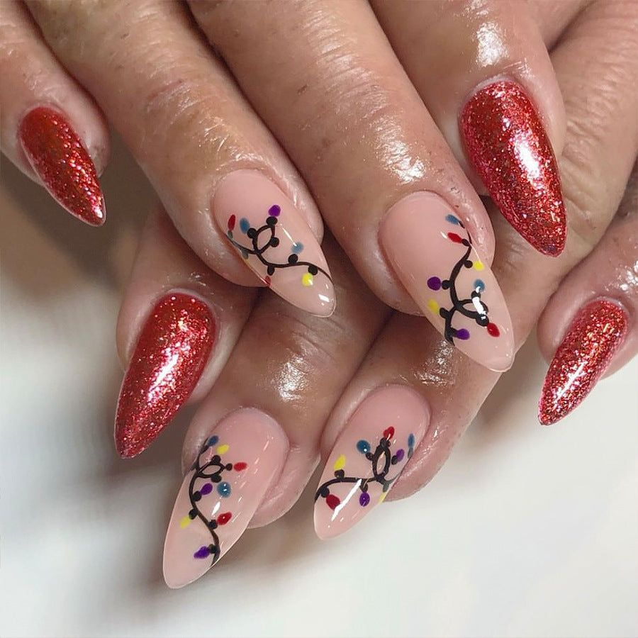 A set of long almond-shaped nails with a red glittery finish and colorful light string designs.