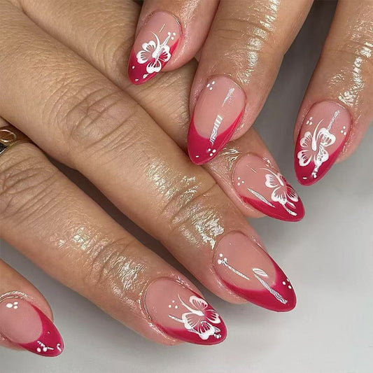 Nails with pink polish and white butterfly designs on a neutral background
