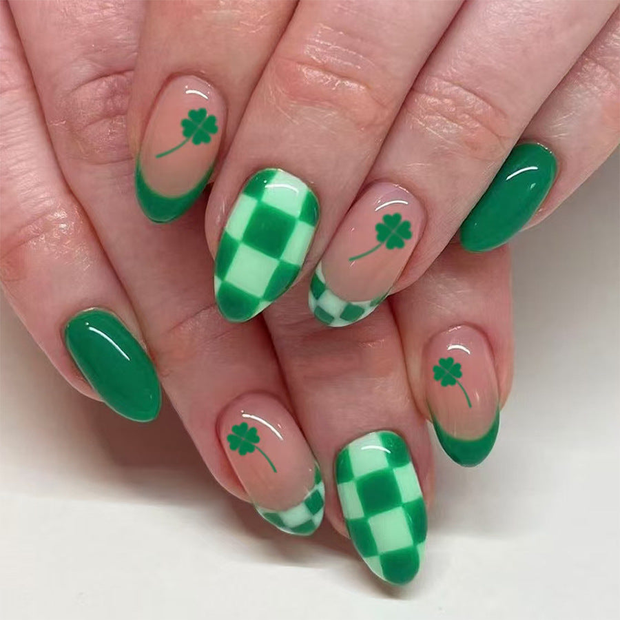 A set of almond-shaped nails with a green and white gingham and floral pattern design.