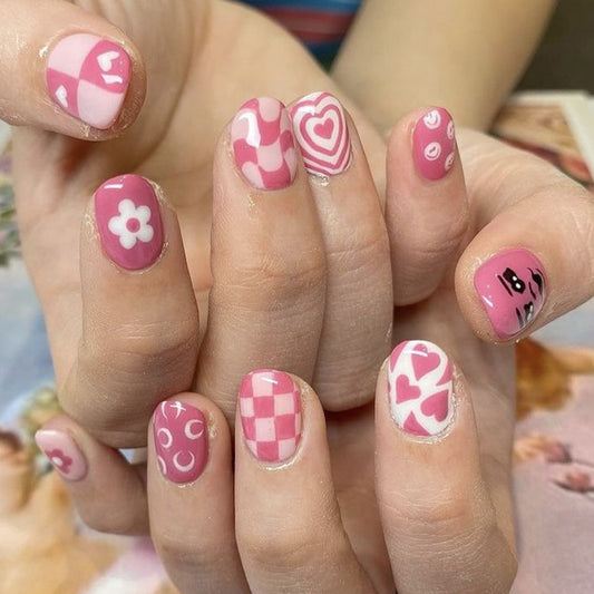 Chic Vintage Inspired Short Oval Pink Nail Set with Playful Patterns and Heart Motifs