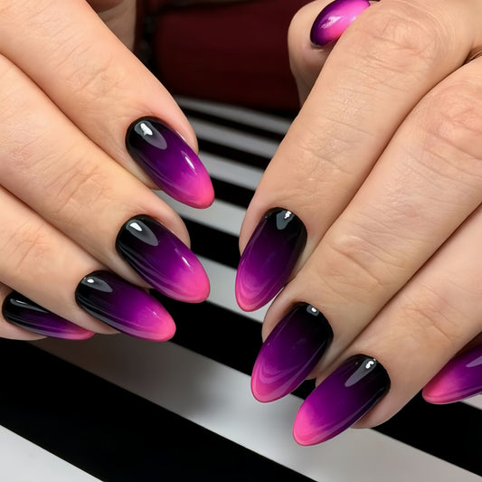 Close-up of hands with purple and black gradient nail polish on a blurred background