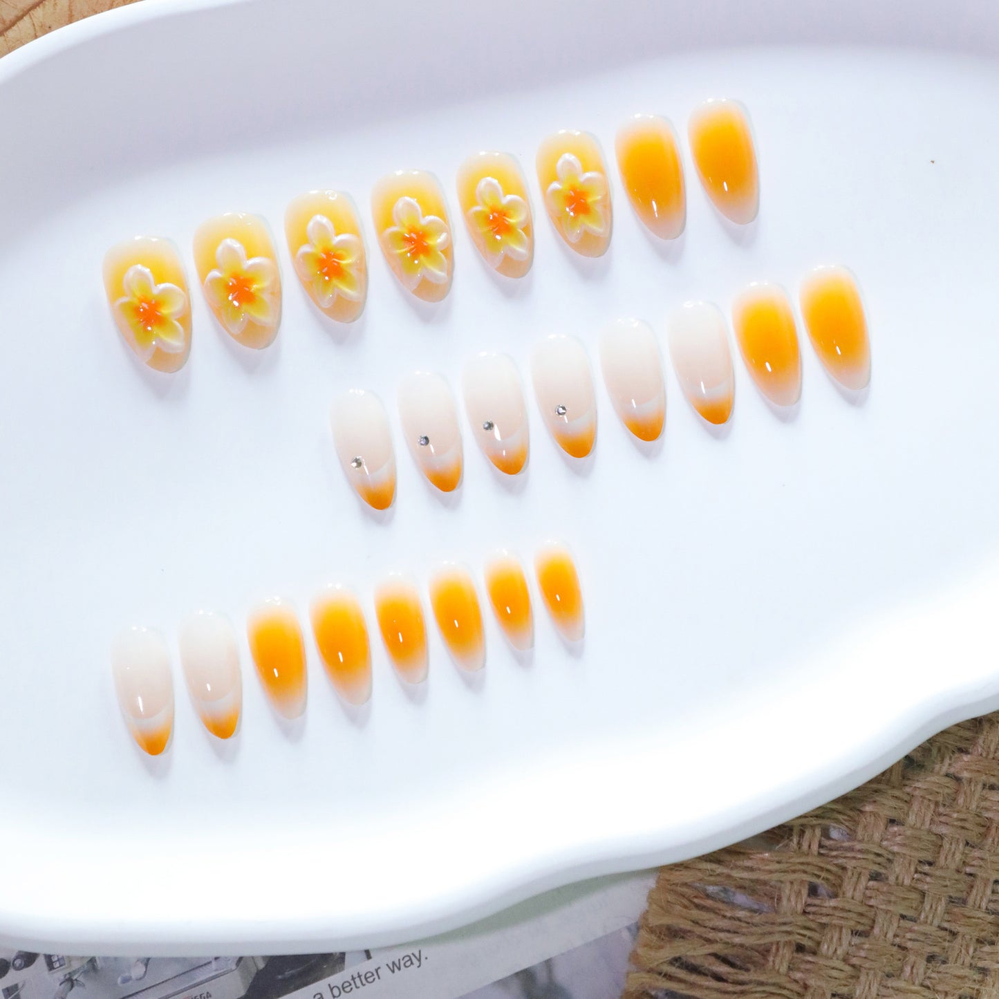 Tropical Sunrise Medium Almond Press-On Nail Set in Ombre Orange Featuring Floral Accents and Sparkling Touches