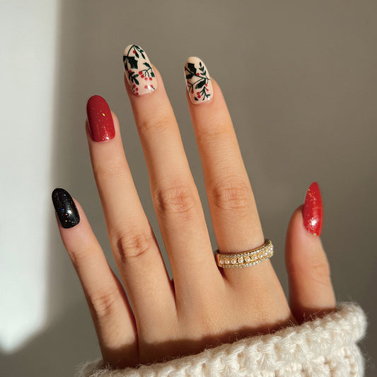 A set of long oval nails with a floral design, featuring a mix of red, black, and cream colors, accented with glitter.