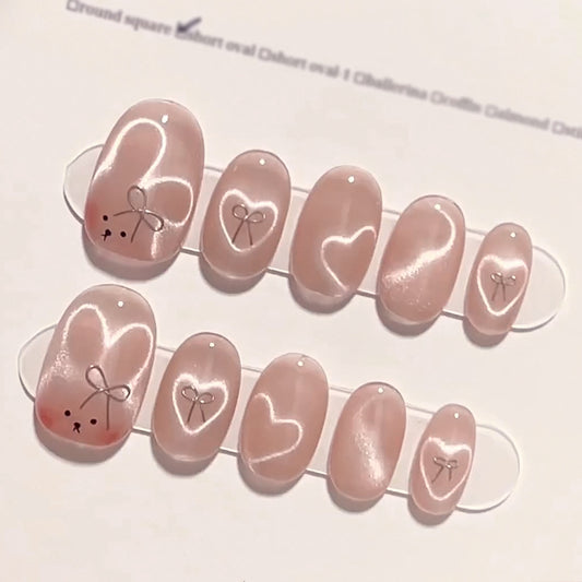 Enchanted Romance Medium Oval Blush Pink Press On Nails with Delicate Heart Accents and Sheer Finish