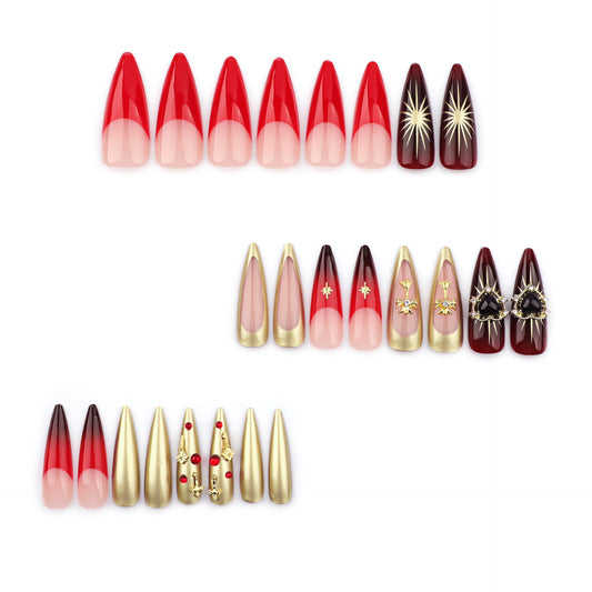 A collection of false nails in various designs, featuring long stiletto shapes in red and gold colors with decorative accents such as stars and floral patterns.