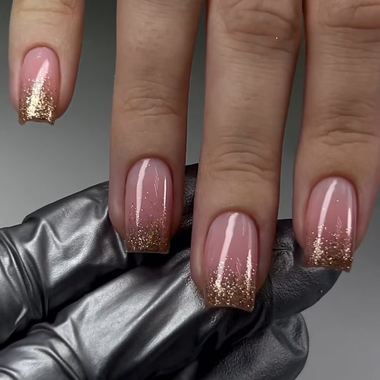 Close-up of a hand with pink nails and gold glitter, wearing a black glove.