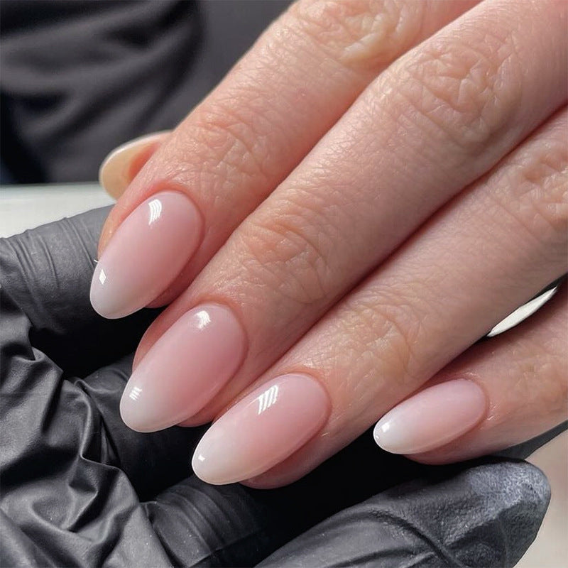 Close-up of a hand with pink nail polish wearing a black glove.