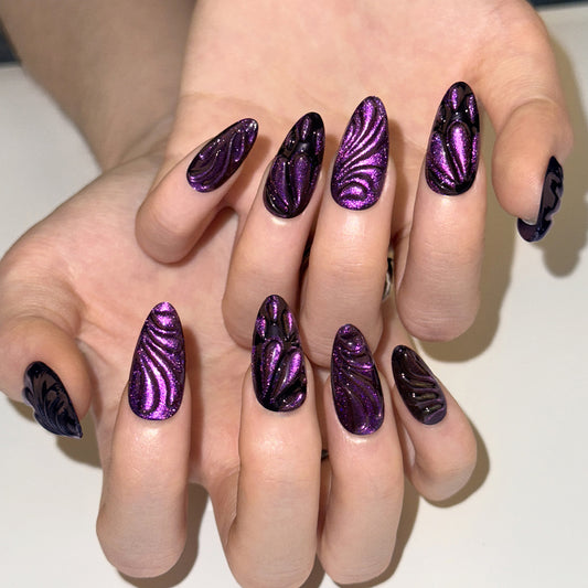 Hand with purple and black zebra-striped nail art on a white background