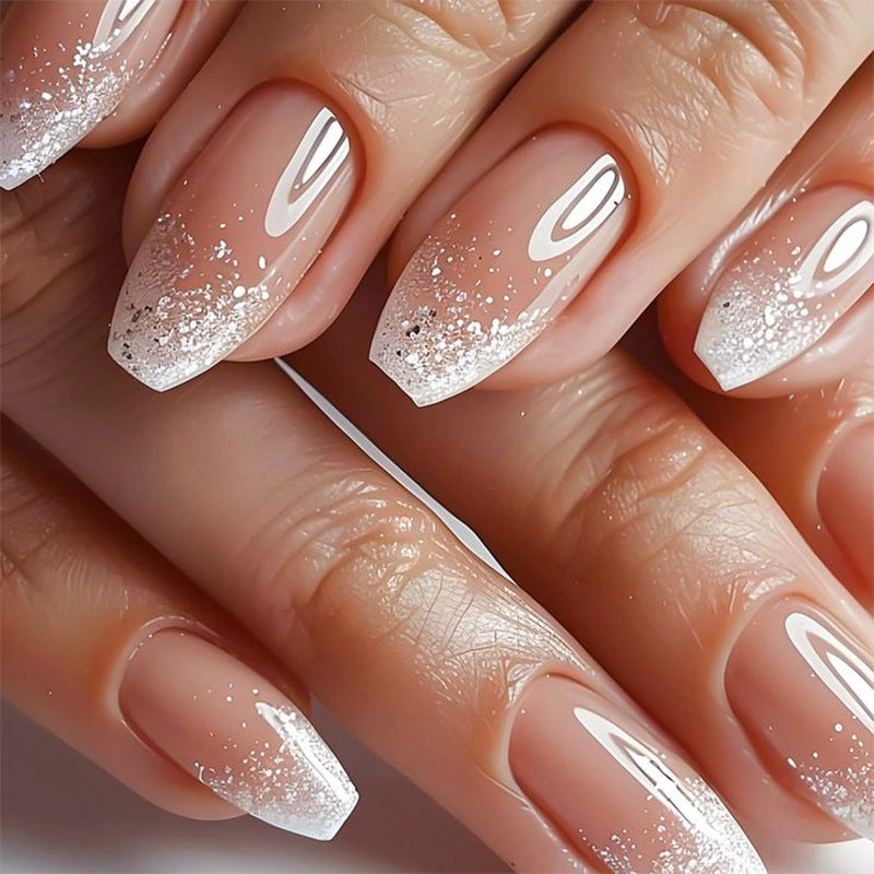 Nails with a gradient design and glittery finish on a neutral background
