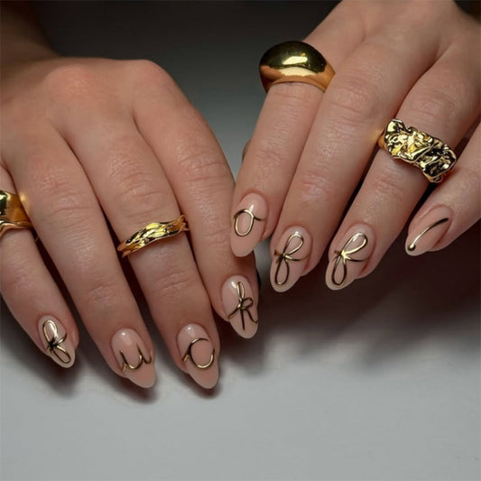 Glamorous Elegance Short Almond Beige Nails with Chic Gold Letter Design