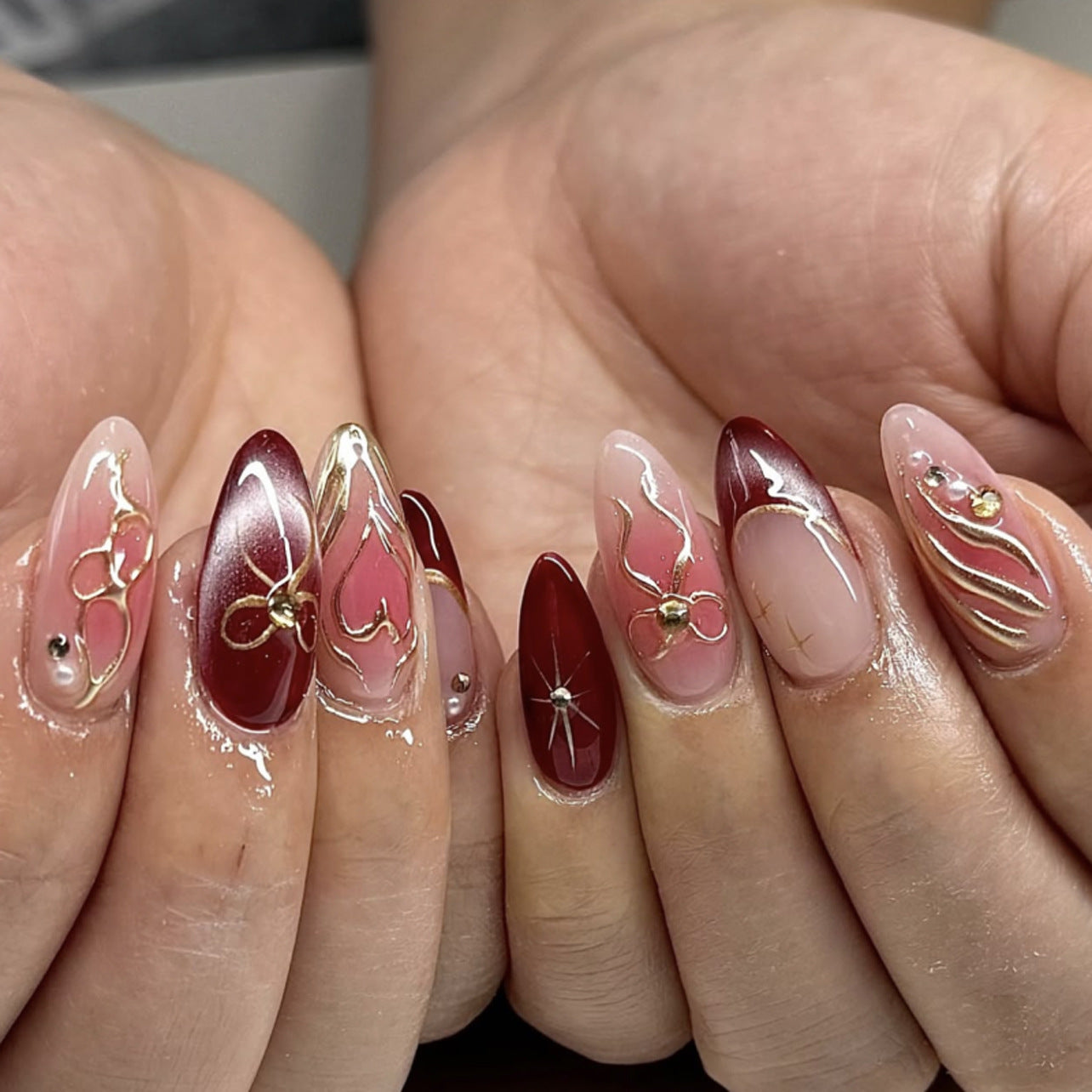 Romantic Elegance Medium Almond Red and Pink Nails with Intricate Gold Accents