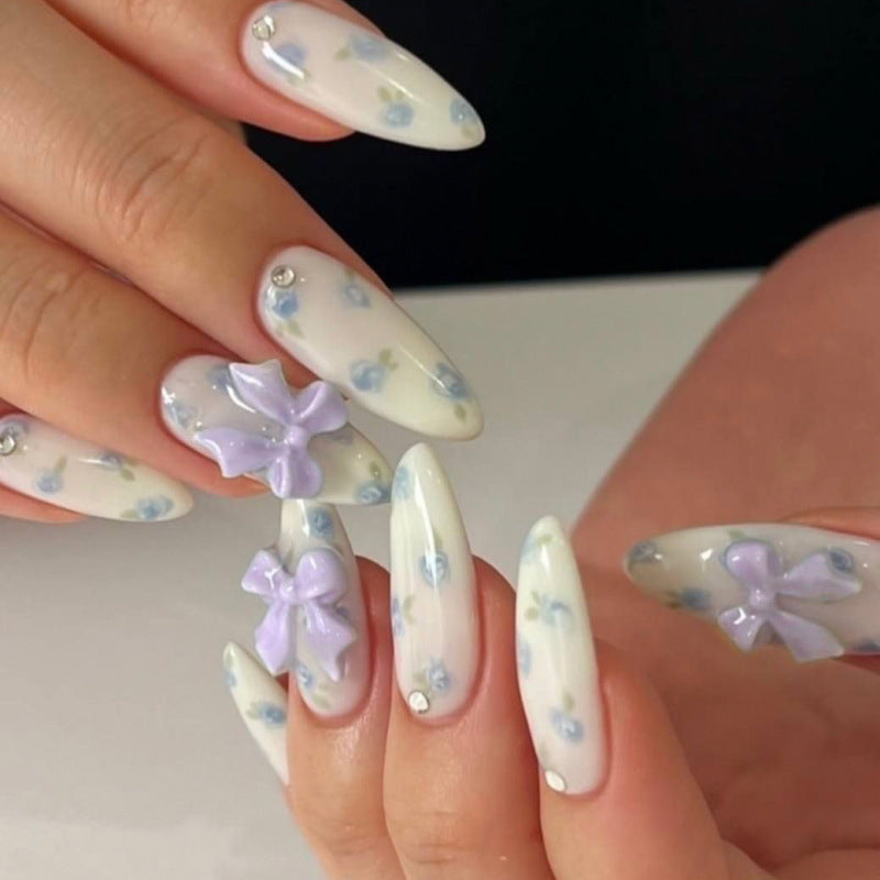 Whimsical Garden Long Almond White Nails with Floral Designs and Three Dimensional Bows