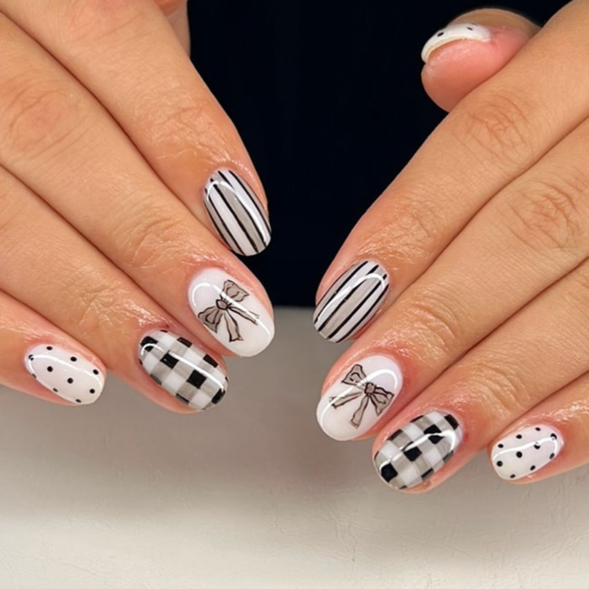 Chic Bowtie Elegance Medium Oval Black and White Press On Nail Set with Unique Patterned Designs