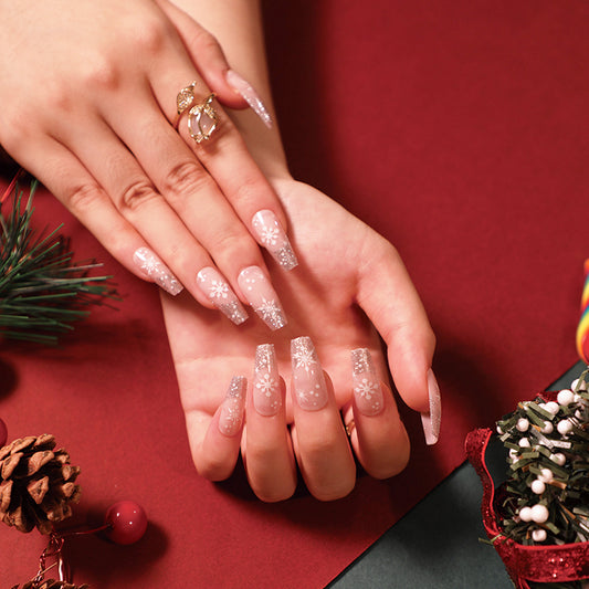 Close-up of hands with decorative nail art on a red background with Christmas decorations.