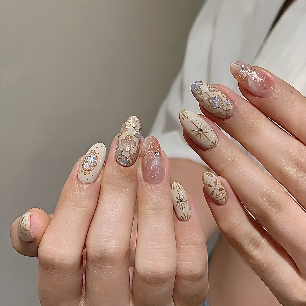 Whimsical Elegance Medium Oval Beige Nails with Glossy Floral Designs and Sparkling Accents