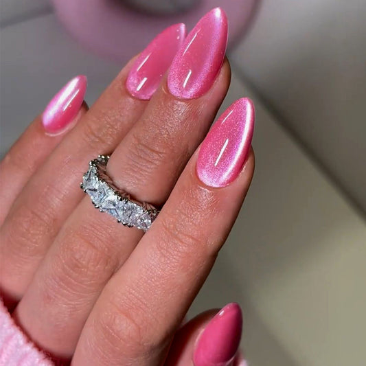 Hand with pink nails and a diamond ring on a neutral background