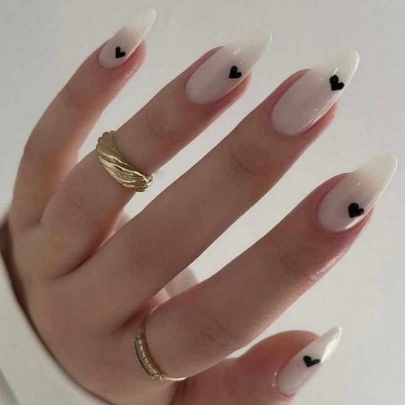 Romantic Elegance Long Almond Shaped White Nails with Charming Black Heart Accents