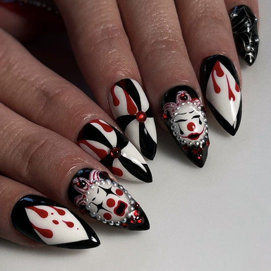 A set of press-on nails featuring a fiery design with clown face details, predominantly in red and black colors.