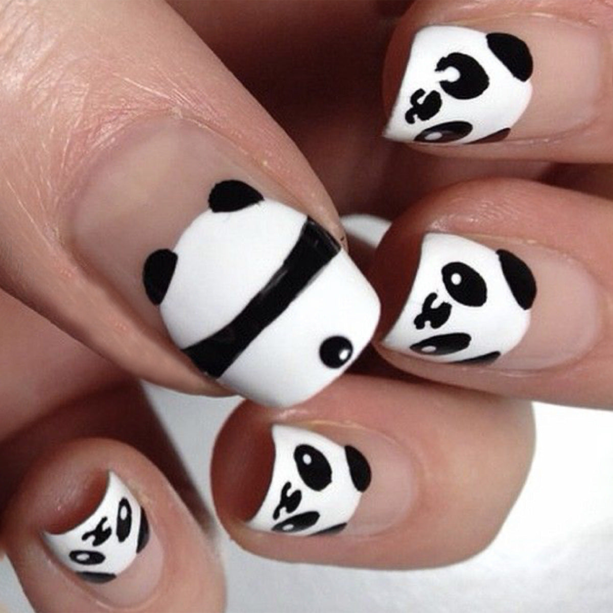 Nails with panda design on a white background