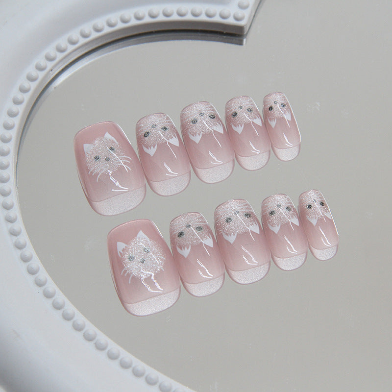 Set of pink nail art with white designs on a gray surface