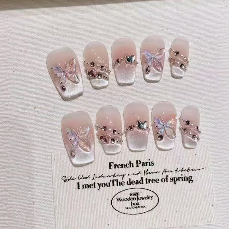 Decorative nails with butterflies and rhinestones on a white background with text.