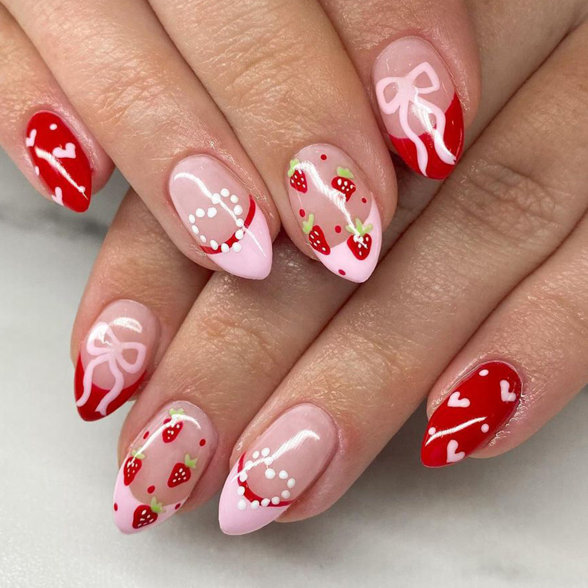 Sweet Strawberry Love Press-On Nail Set in Short Almond Shape with Radiant Red and Soft Pink Colors Featuring Charming Heart and Bow Designs