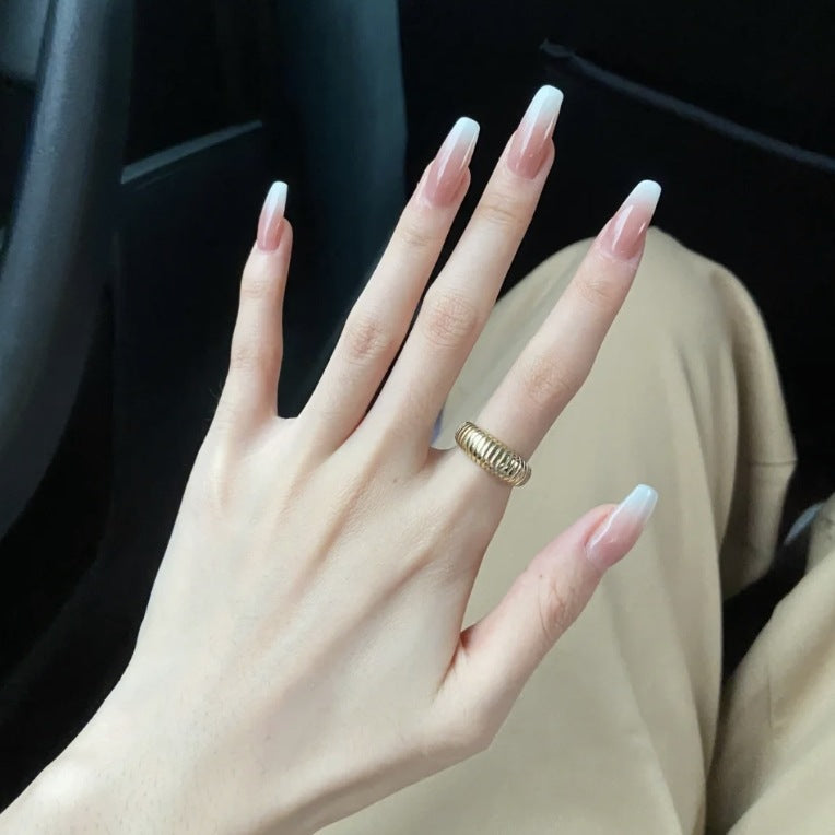 Hand with a gold ring and manicured nails in a car interior