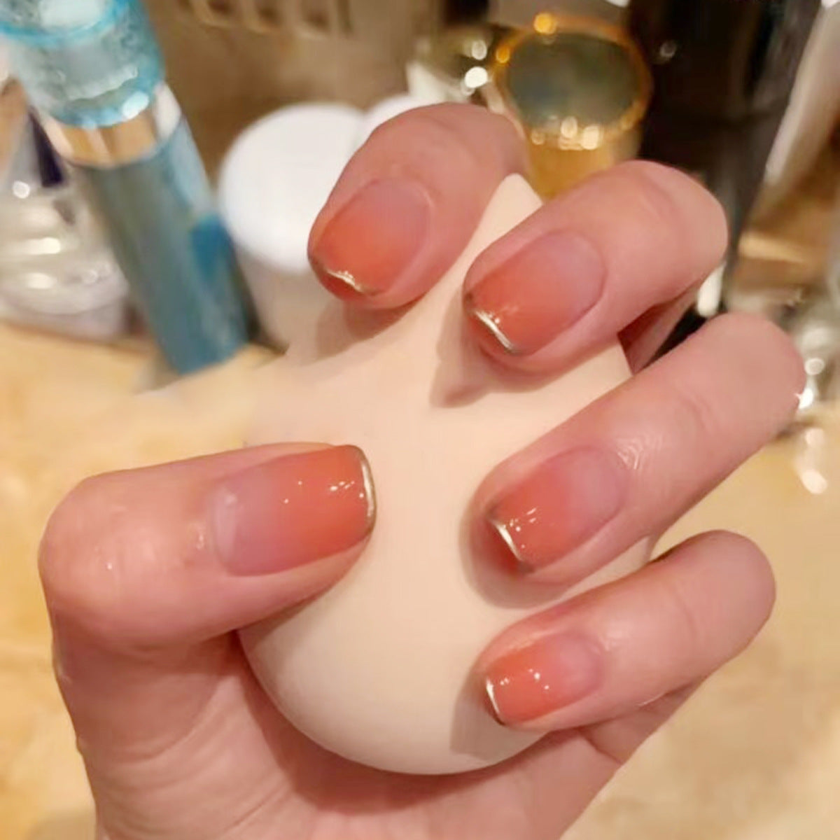 Glamorous Sunset Short Square Nails in Warm Peach with Elegant Gold Tips