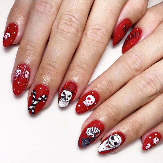 Close-up of hands with red nail polish and skull designs on a white background