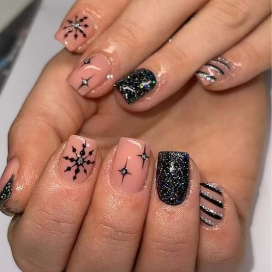 Nails with various designs including stars and glitter on a neutral background