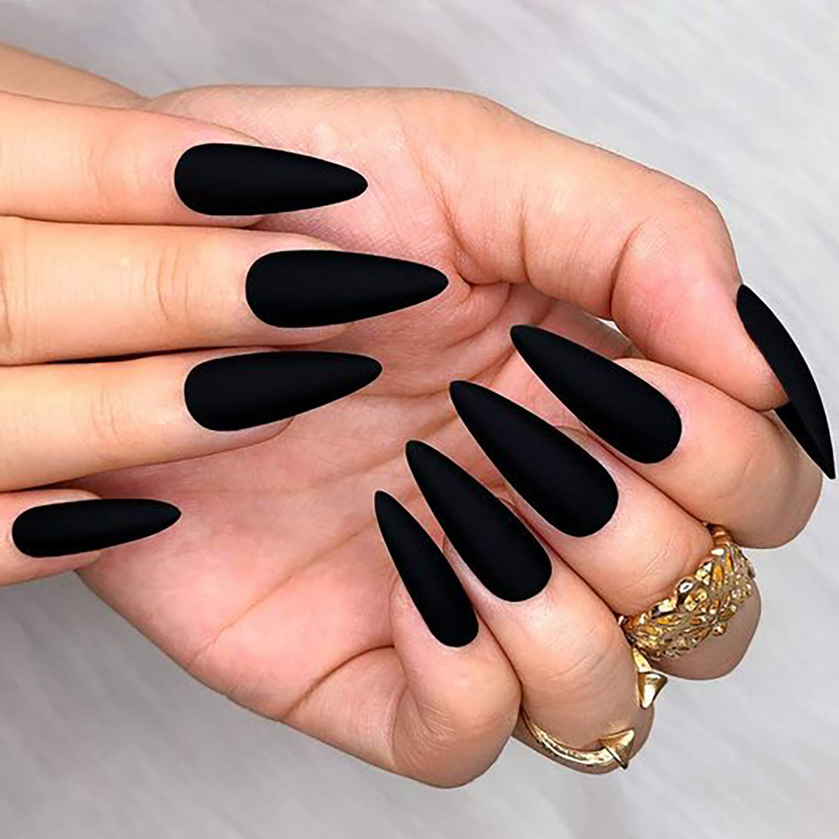 Hand with black nail polish on a plain background