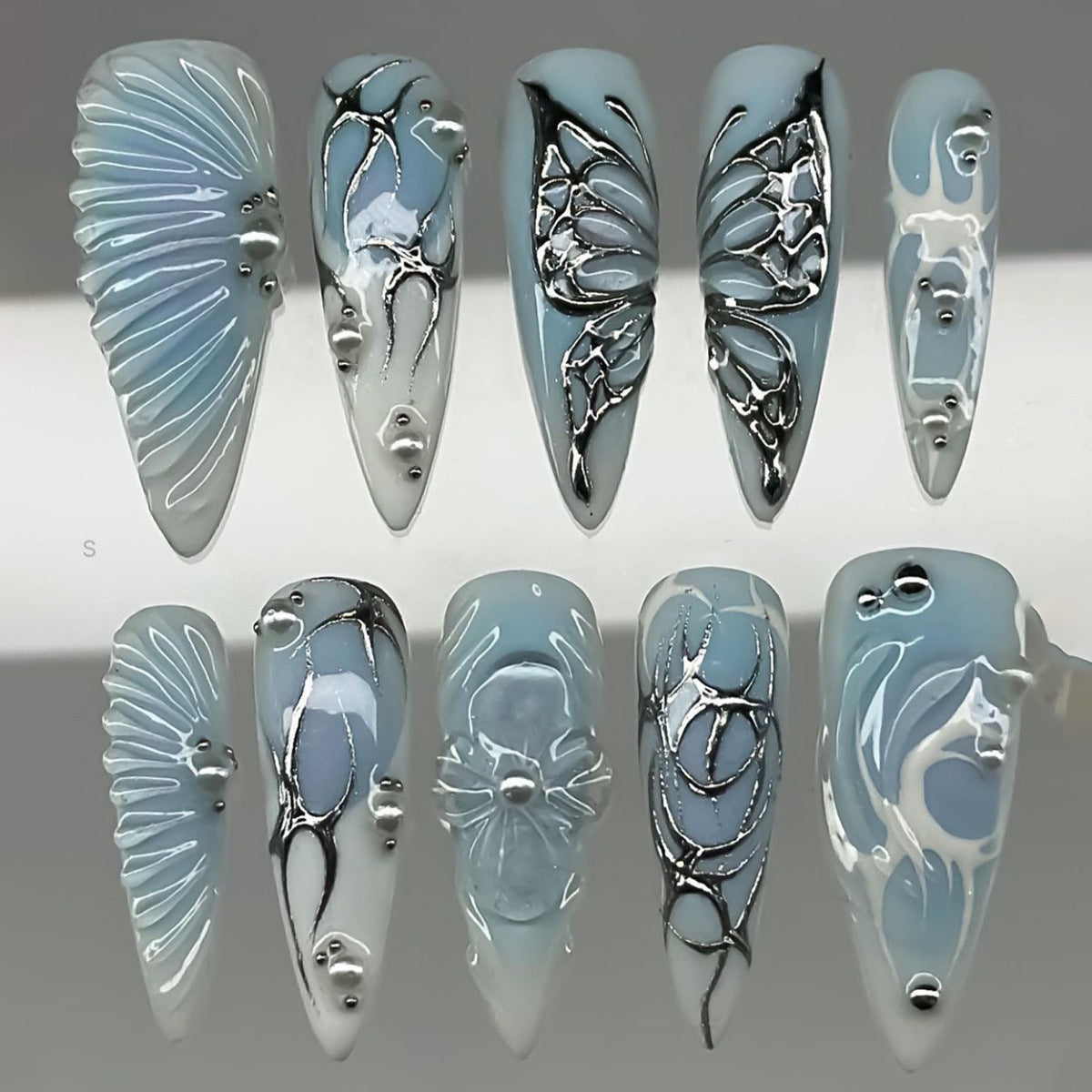 Whimsical Serenity Long Stiletto Blue Nails with Silver Embellishments and Artful Designs