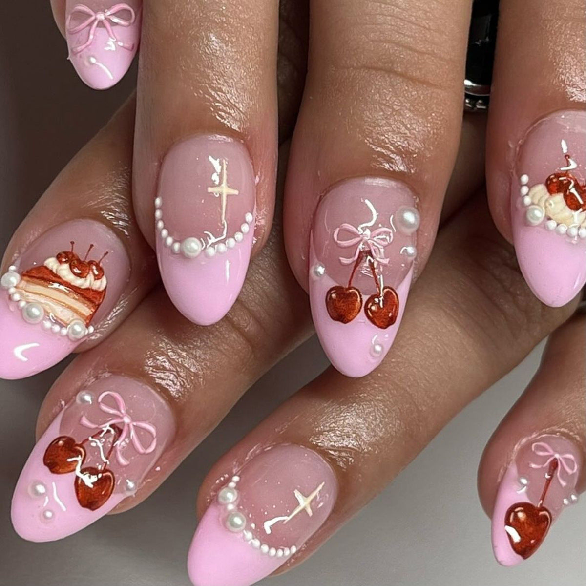 Pink nail art with decorative elements on a neutral background