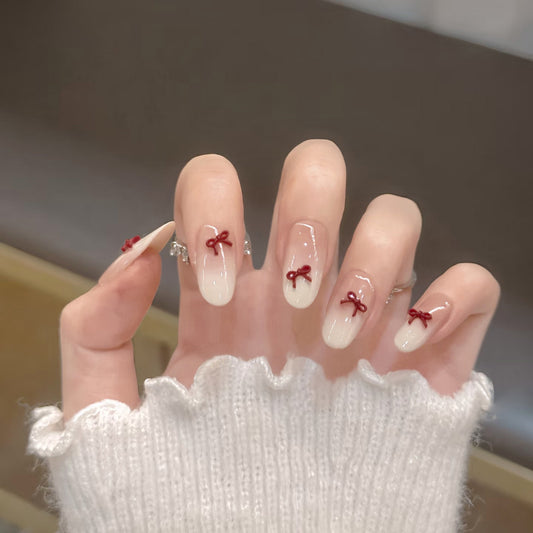 Whimsical Elegance Medium Oval Beige Press On Nail Set with Charming Red Ribbon Accents