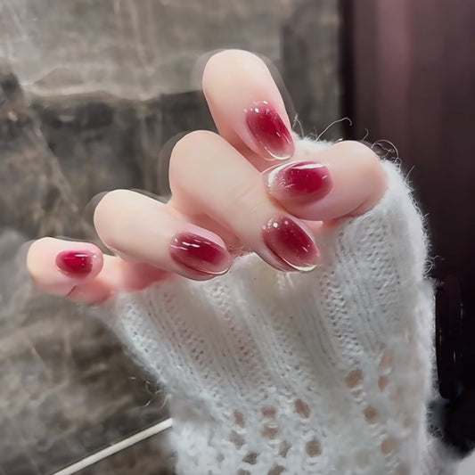 Close-up of a hand with red nail polish wearing a white textured sweater.