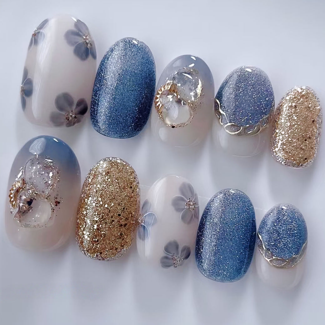 Set of nail designs with blue, gold, and white colors on a white background