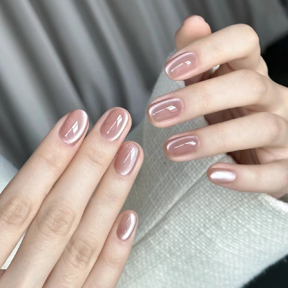 Close-up of hands with pink nail polish against a neutral background
